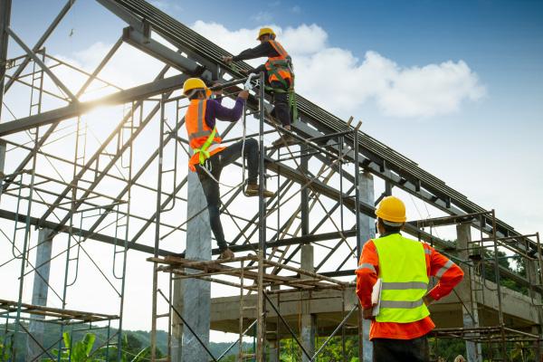 Construction Site Safety and Compliance Workers at a construction site climbing on equipment