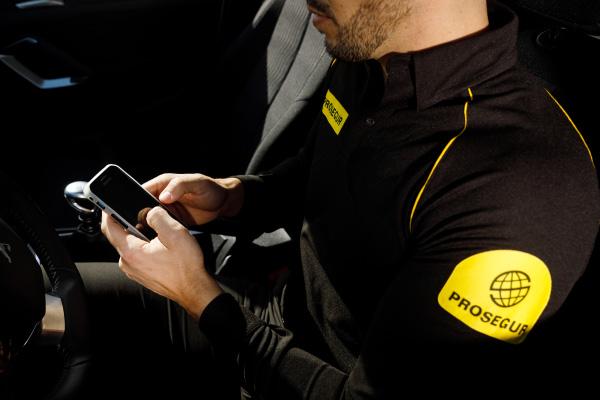 Prosegur Security Guard A Prosegur security officer using his phone to log information