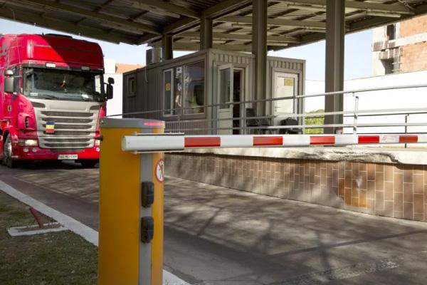 Logistics Access Control A commercial truck waiting at a security checkpoint to exit a truckyard